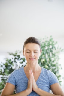 Serene Caucasian woman with hands in prayer position