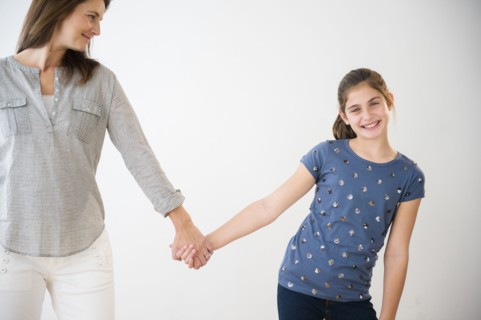Portrait of smiling Caucasian daughter holding hands with mother