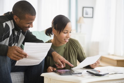 Couple paying bills in living room