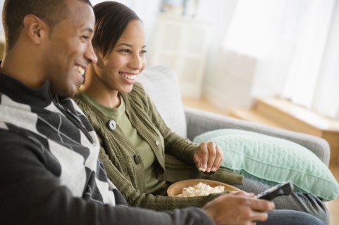 Couple with popcorn watching TV in living room