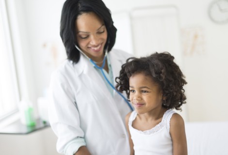 African American girl receiving checkup from doctor
