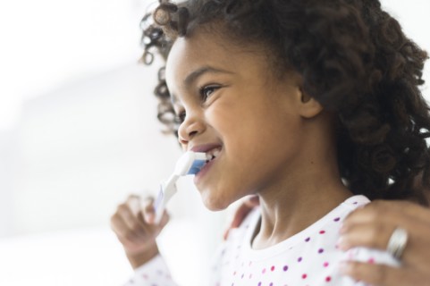 Close up of African American girl brushing teeth