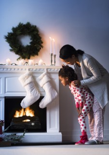 Black mother and daughter looking at Christmas stockings