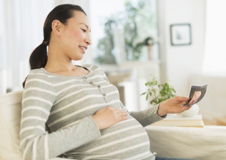 Pregnant Japanese woman looking at ultrasound image