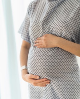 Close up of pregnant Japanese woman in hospital gown