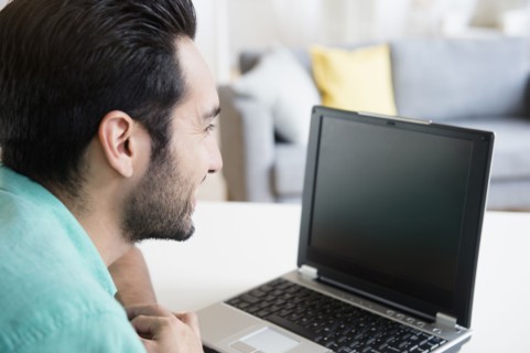 Mixed race man using laptop
