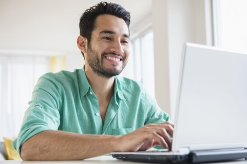 Mixed race man using laptop
