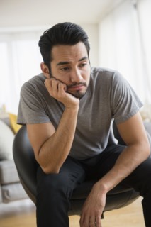 Mixed race man resting chin in hand