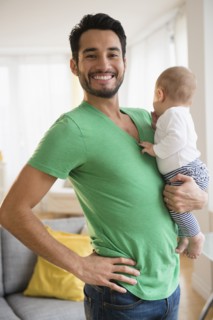 Father holding baby in living room