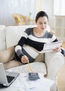 Pregnant Caucasian woman paying bills