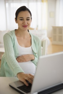 Pregnant Caucasian woman using laptop