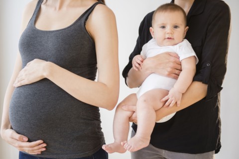 Pregnant Caucasian woman with friend and baby