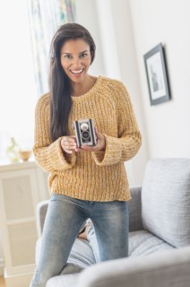 Hispanic woman using vintage camera