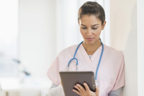 Hispanic nurse using digital tablet in hospital