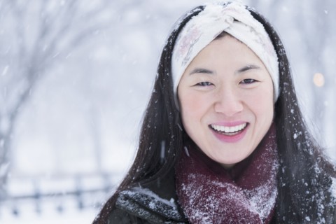 Asian woman smiling in snow