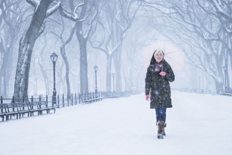 Asian woman walking in snowy Central Park