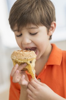 Hispanic boy eating muffin