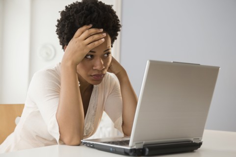 Frustrated Black businesswoman using laptop