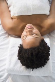 Serene Black woman laying on massage table