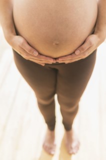 Pregnant Hispanic woman holding her belly