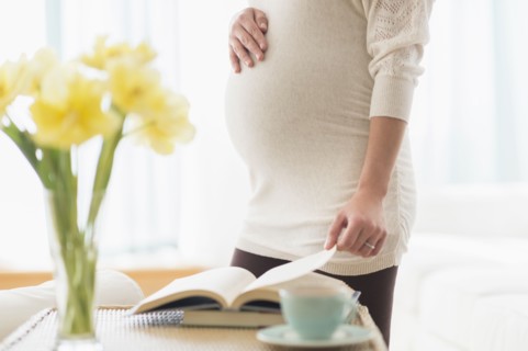 Pregnant Hispanic woman reading book