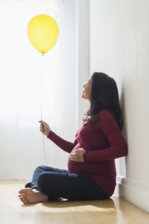 Pregnant Hispanic woman holding balloon