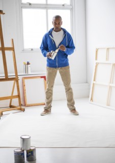 Black artist painting in studio