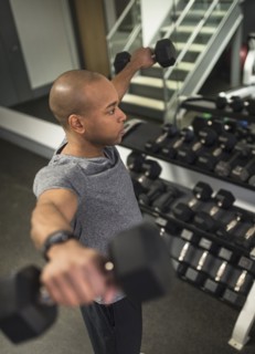 Black man lifting weights in gym
