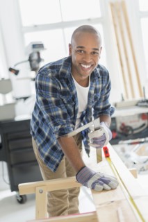 Black carpenter working in shop