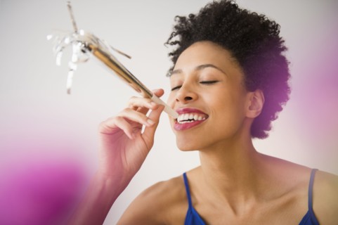 Black woman blowing noisemaker at party