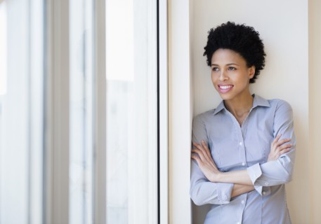 Black businesswoman smiling by window
