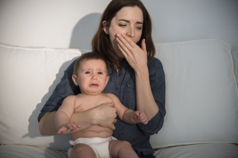 Tired mother holding crying baby