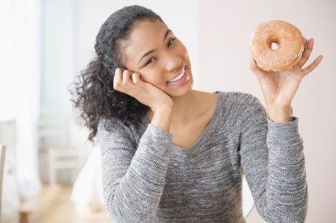 Mixed race woman holding donut