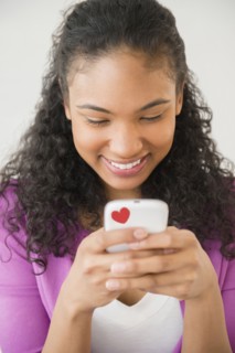 Mixed race woman using cell phone