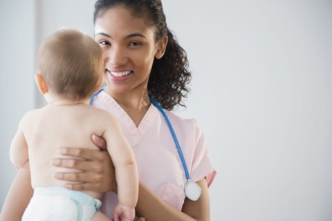 Nurse holding baby in hospital