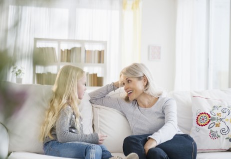 Senior Caucasian woman and granddaughter talking on sofa