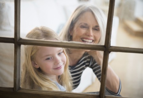 Senior Caucasian woman and granddaughter looking out window