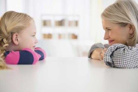 Senior Caucasian woman and granddaughter sitting at table