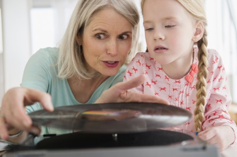 Senior Caucasian woman and granddaughter listening to records
