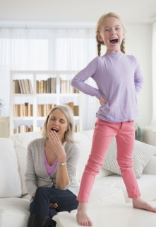 Tired Senior Caucasian woman playing with granddaughter
