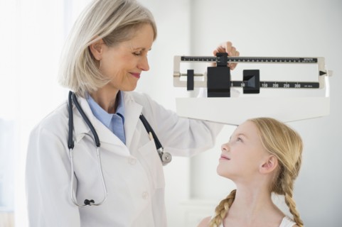 Caucasian doctor weighing patient