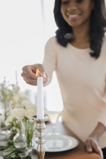 African American woman lighting candle