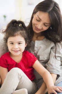 Hispanic mother and daughter sitting together
