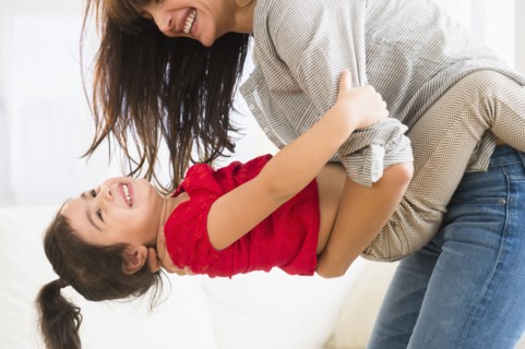 Hispanic mother and daughter playing together