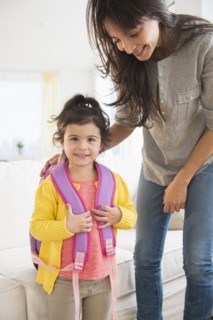 Hispanic mother getting daughter ready for school