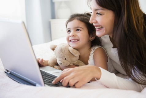 Hispanic mother and daughter using laptop together