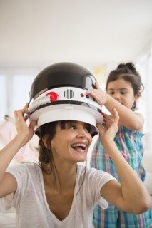 Hispanic mother and daughter playing dress up