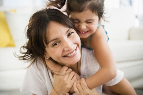 Hispanic mother and daughter playing in living room