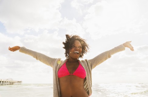 African American woman cheering on beach