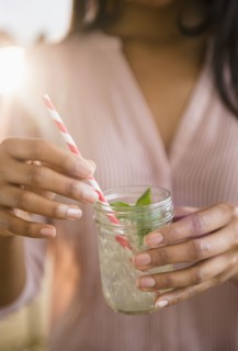 Mixed race woman drinking cocktail